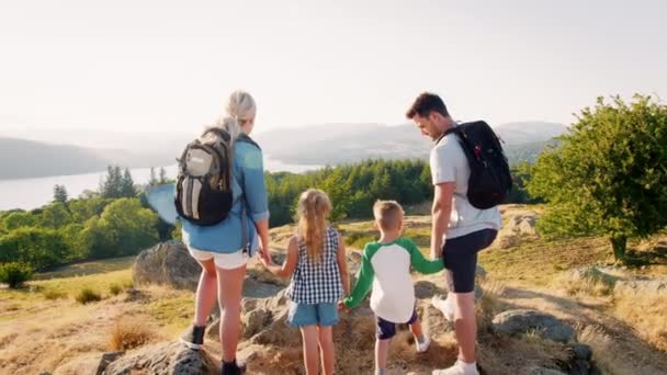 Bakifrån Familjemedlem Bär Ryggsäckar Stående Toppen Kullen Vandring Genom Lake — Stockvideo