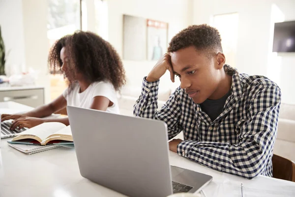 黑人十几岁的弟弟和妹妹在家里使用笔记本电脑工作 — 图库照片