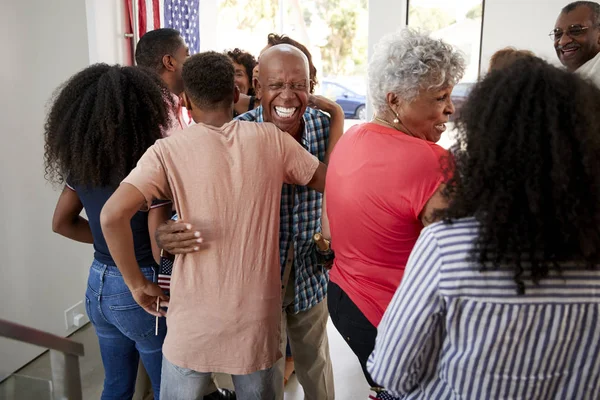 独立記念日パーティーにゲストを歓迎する3世代の黒人家族 — ストック写真