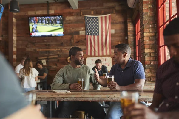 两个男性朋友会议在体育酒吧享受饮料前游戏 — 图库照片