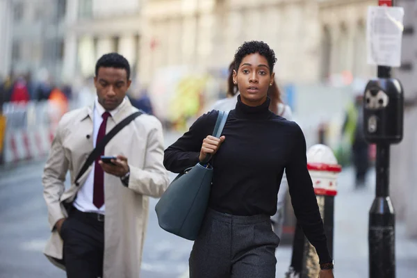 ロンドンの通りを歩く若い黒人女性のハンドバッグ フロントビューを運ぶ — ストック写真
