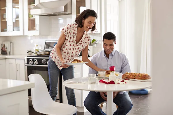 Hombre Adulto Joven Sentado Mesa Cocina Mujer Sirviendo Una Comida —  Fotos de Stock