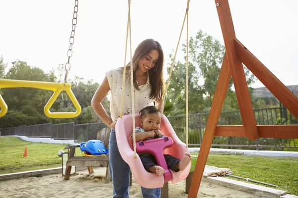 Jovem Mãe Hispânica Empurrando Seu Bebê Balanço Playground Parque — Fotografia de Stock