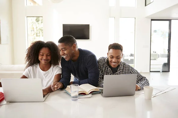 Sorrindo Pai Ajudando Seus Filhos Adolescentes Com Seus Deveres Casa — Fotografia de Stock