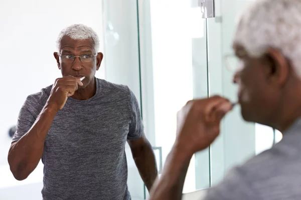 Старший Чоловік Дивиться Відображення Ванній Дзеркало Піжамі Чистячі Зуби — стокове фото
