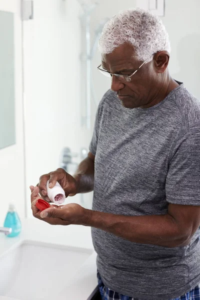 Homem Sênior Espelho Banheiro Vestindo Pijamas Tomando Suplemento Vitamínico Tablet — Fotografia de Stock