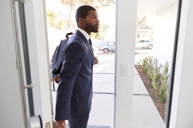 Businessman Wearing Suit Opening Door Leaving Home For Work clipart