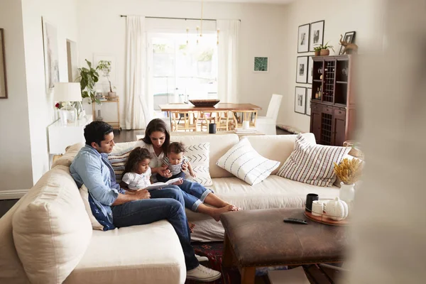 Young Hispanic Family Sitting Sofa Reading Book Together Living Room — Stock Photo, Image