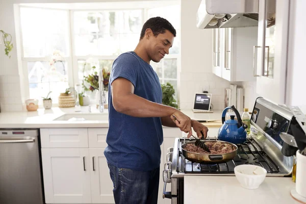Genç Yetişkin Siyah Adam Mutfakta Spatula Kızartma Tavası Kullanarak Yemek — Stok fotoğraf