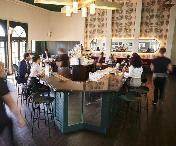 顧客にサービスを提供するスタッフとレストランで忙しいカクテルバーのインテリア — ストック写真
