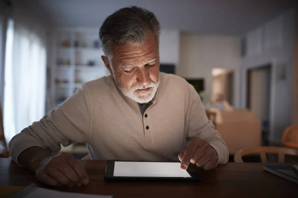 Älterer Hispanischer Mann Der Abends Mit Einem Tablet Computer Hause — Stockfoto