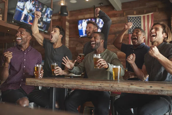 Grupa Męskich Przyjaciół Obchodzi Podczas Oglądania Gry Ekranie Barze Sportowym — Zdjęcie stockowe