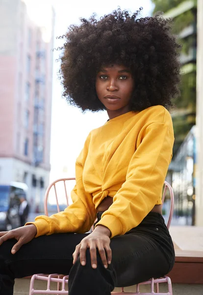 Siyah Saçlı Genç Bir Kadın Sokakta Bir Sandalyede Oturmuş Dikey — Stok fotoğraf