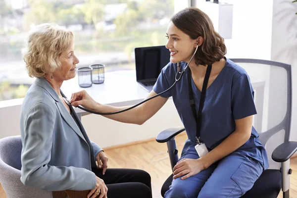 Médico Femenino Usando Exfoliantes Oficina Escuchando Pacientes Mayores Usando Estetoscopio — Foto de Stock