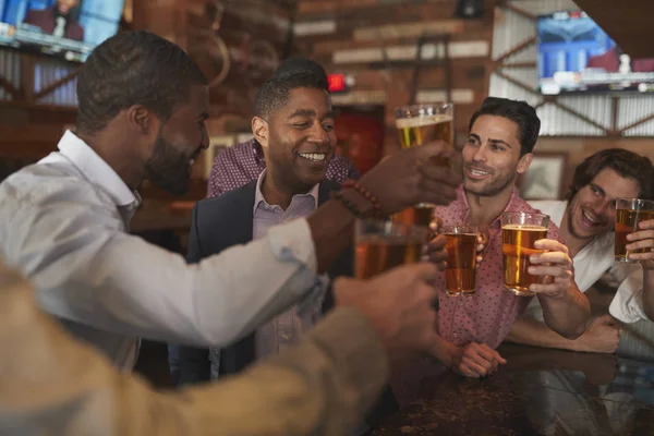 一緒に乾杯するバーで独身パーティーのために夜に男性の友人のグループ — ストック写真
