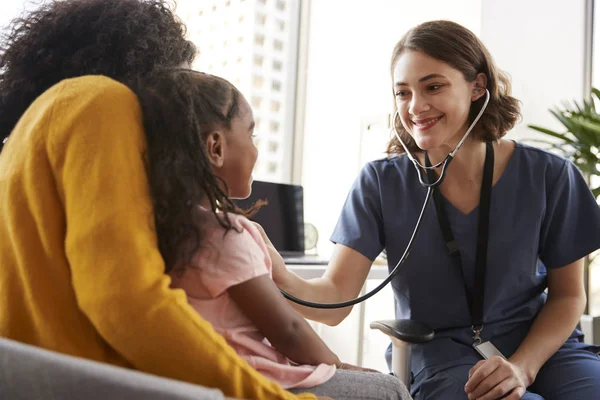 Female Pediatrician Wearing Scrubs Listening Girls Chest Stethoscope Hospital Office — Stock Photo, Image