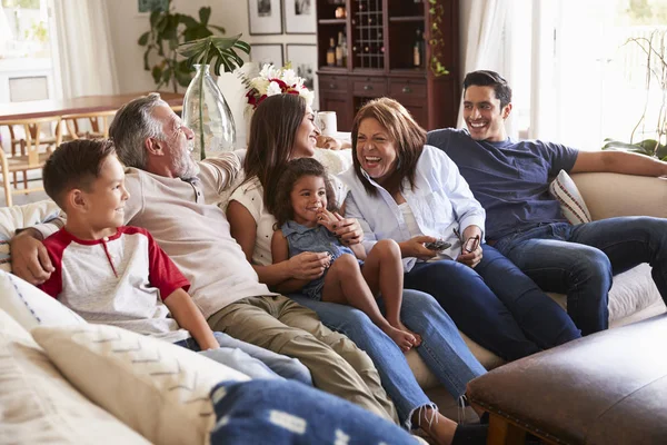 テレビを見てソファに座っている3世代ヒスパニック家族 リモコンを使った祖母 — ストック写真