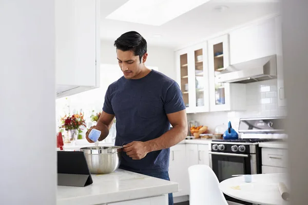 Millennial Hispanic Man Preparing Cake Mixture Kitchen Recipe Tablet Computer — Stock Photo, Image