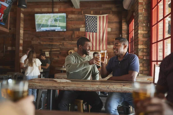 两个男性朋友会议在体育酒吧一起做吐司 — 图库照片