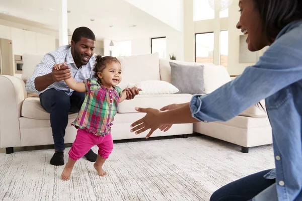 Family Home Encouraging Baby Daughter Take First Steps — Stock Photo, Image