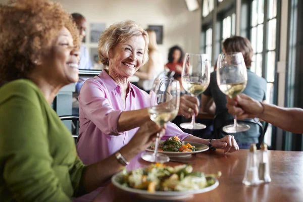 Lächelnde Seniorinnen Stoßen Beim Essen Restaurant — Stockfoto