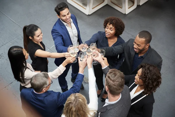 商业团队在现代办公室用香槟吐司庆祝成功的头顶照片 — 图库照片
