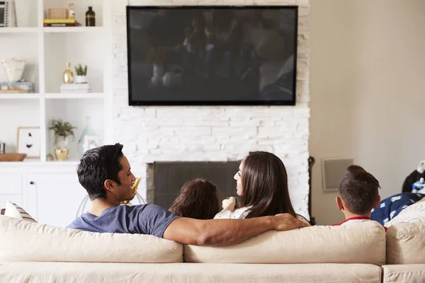 ソファに座ってテレビを見ている4人の若いヒスパニック系家族のバックビュー お父さんを見てお母さん — ストック写真