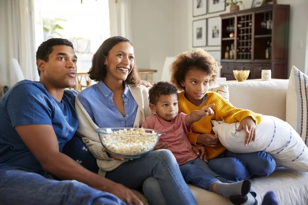 Joven Familia Sentada Junta Sofá Sala Estar Viendo Televisión Comiendo — Foto de Stock