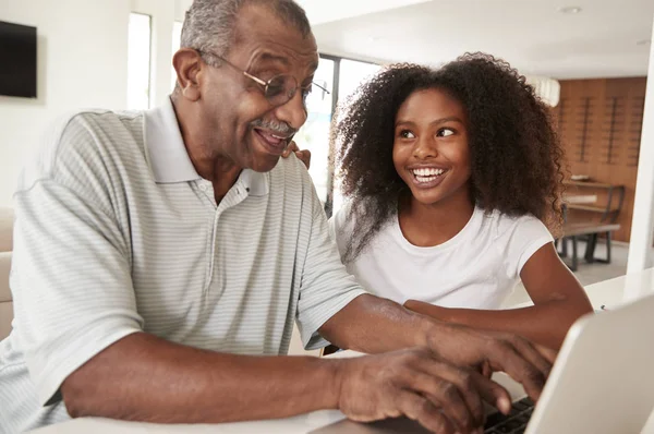 Gülümseyen Genç Siyah Kız Dizüstü Bilgisayar Kullanarak Dedesi Yardım Evde — Stok fotoğraf