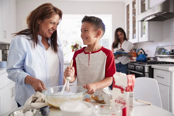 Передчасний Хлопчик Робить Торт Кухні Своєю Бабусею Його Мама Стоїть — стокове фото