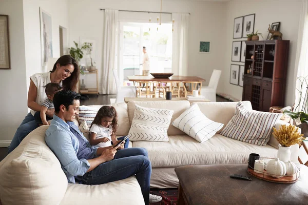 年轻的西班牙裔家庭坐在沙发上 一起在客厅看书 — 图库照片