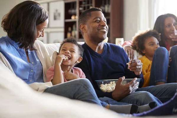 Familia Tres Generaciones Sentada Sofá Sala Estar Viendo Televisión Comiendo —  Fotos de Stock