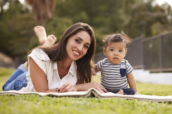 Millennial Mãe Hispânica Deitada Cobertor Parque Com Seu Bebê Sorrindo — Fotografia de Stock