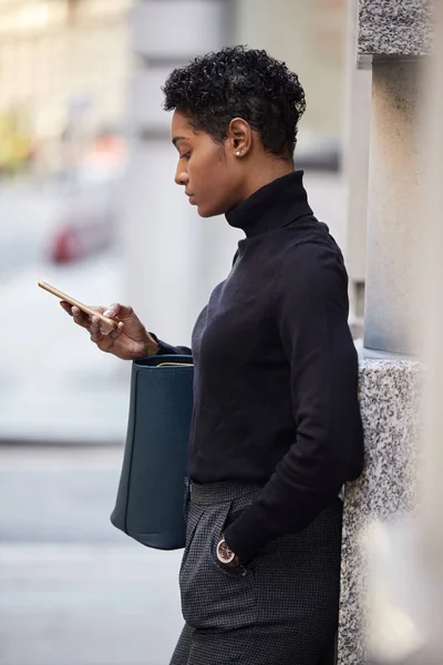 ロンドンの通りに立っている若い黒人女性彼女のスマートフォン サイドビュー 閉じる — ストック写真
