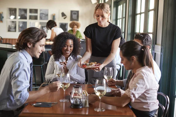 Camarera Sirviendo Comida Compañeros Negocios Sentados Alrededor Mesa Del Restaurante —  Fotos de Stock
