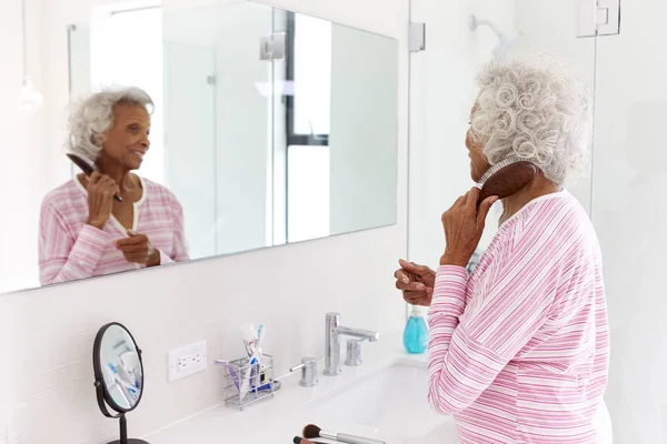Старшая Женщина Смотрит Отражение Ванной Комнате Зеркало Расчесывания Волос — стоковое фото
