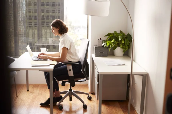 在现代办公室的笔记本电脑上 女商人坐在办公桌前工作 — 图库照片