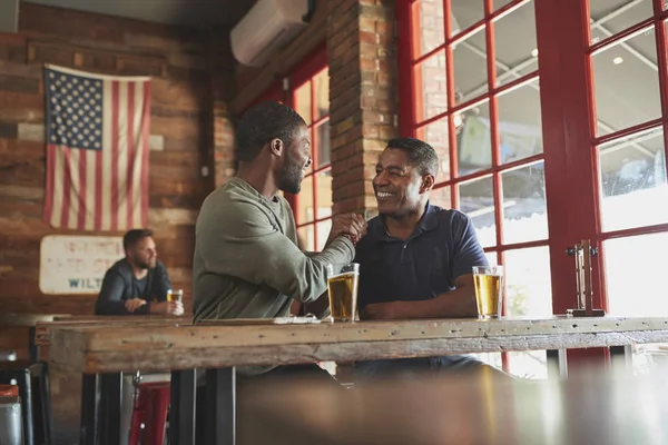 两个男性朋友在体育酒吧互相问候 一起喝酒 — 图库照片