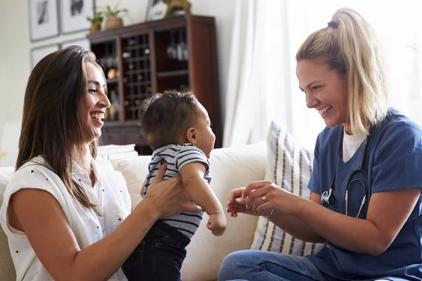 自宅で若い母親と彼女の幼児の息子を訪問する女性の医療従事者 — ストック写真