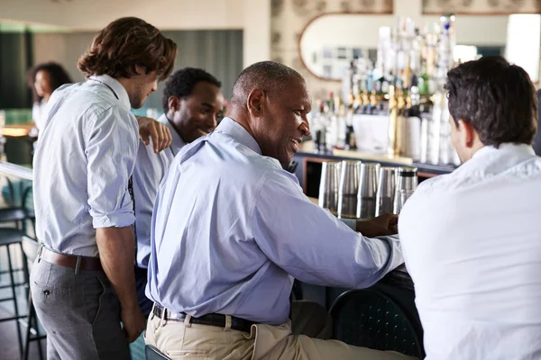 バーで仕事の後の飲み物のためのビジネスマン会議の背面図 — ストック写真