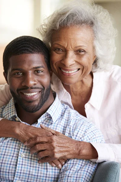 微笑的老年母亲拥抱成年儿子在家里的肖像 — 图库照片