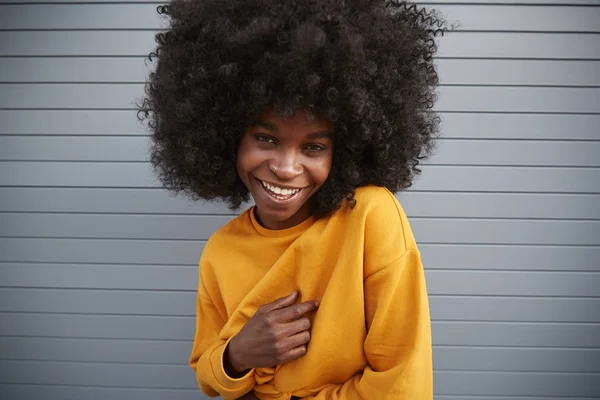 Mladá Černoška Afro Proti Šedé Zdi Zvedá Rameno Usmívá Kameru — Stock fotografie