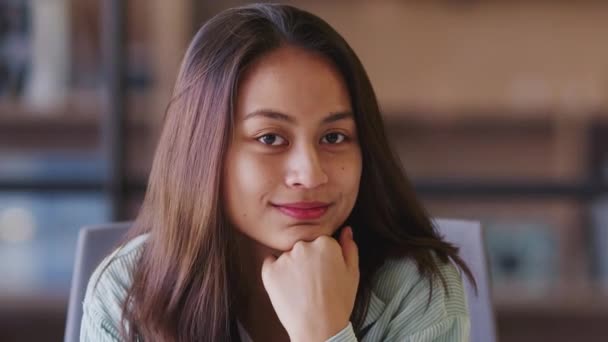 ミレニアルアジアの女性クリエイティブは 手にあごを休ませ カメラに微笑み クローズアップオフィスに座っています — ストック動画