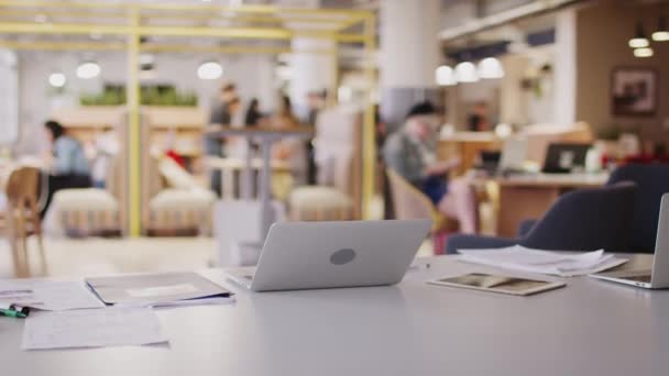 Laptop Computer Und Papierkram Auf Dem Schreibtisch Einem Kreativen Großraumbüro — Stockvideo