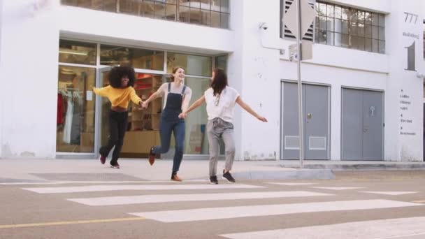 Три Девушки Тысячелетия Держатся Руки Смеются Пересекают Пешеходный Переход — стоковое видео