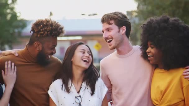 6人のミレニアル世代のヒップスターの友人がカメラに微笑み パンニングショットに笑顔で街の通りに立っている — ストック動画