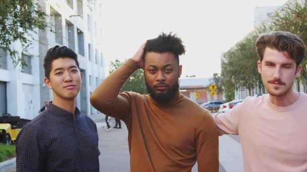 三个年轻的成年男性朋友站在城市街道寻找相机 前视图 — 图库视频影像