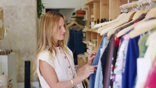 Kundin Blickt Durch Regale Modehaus Und Wählt Jeans Aufgenommen Zeitlupe — Stockvideo