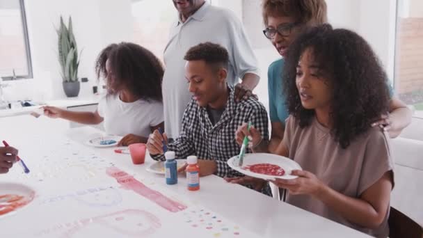 三个年轻的黑人成年人在厨房里和家人一起做一个惊喜派对的标志 — 图库视频影像
