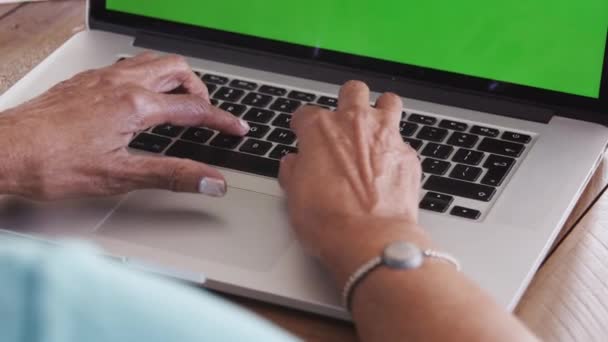 一位坐在桌旁用笔记本电脑键盘打字的黑人老妇人的手特写 — 图库视频影像